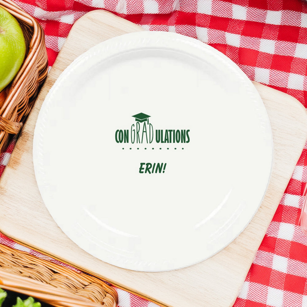 This charming white plastic graduation dinner plate, personalized in hunter green print and set against a festive red-and-white checkered tablecloth, proudly congratulates the honorary graduate with a simple yet heartfelt message: "CONGRATULATIONS ERIN!" Adorned with a graduation cap graphic, it captures the joy of achievement. Paired with a rustic picnic vibe, this dinner plate is a delightful centerpiece for celebrating the graduate's bright future!