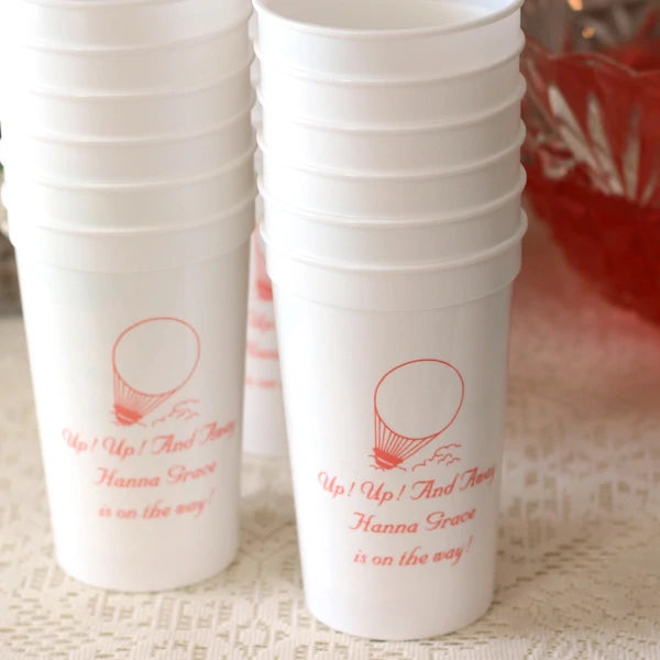 White 22 oz. plastic baby shower stadium cups personalized with up, up and away design and 2 lines of custom text in coral print