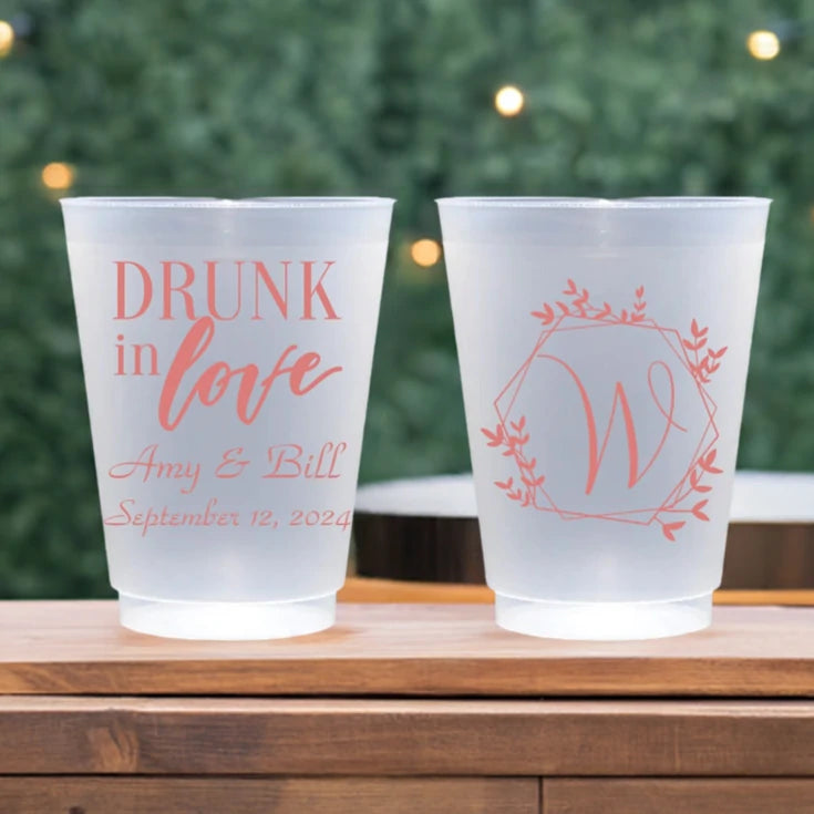 Clear frosted plastic wedding glasses custom printed with drunk in love design and custom text on fron side and geo wreath monogram initial on back side in coral print