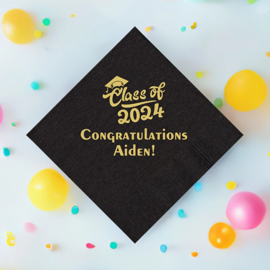 black graduation cocktail napkins personalized with class of 2024 script design and 2 lines of custom text in gold print