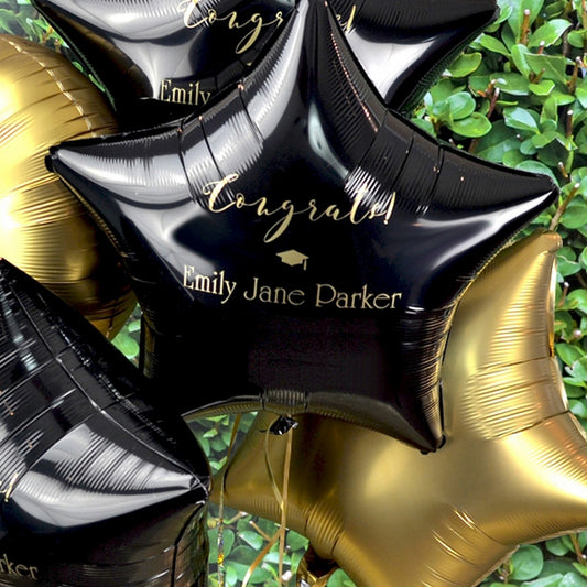 Black mylar star shape graduation balloons personalized with congrats grad cap design and custom text in gold print.