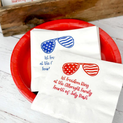 White paper summer party luncheon napkins personalized with star spangled sunglasses design and 3 lines of text in red and blue print for fourth of july picnic