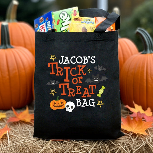 Black Halloween tote with personalized Jacobs name pumpkin skull and bats personalized trick or treat bag filled with candy