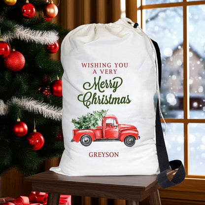Pro Gift Source Santa sack featuring a red truck carrying a Christmas tree with festive greetings
