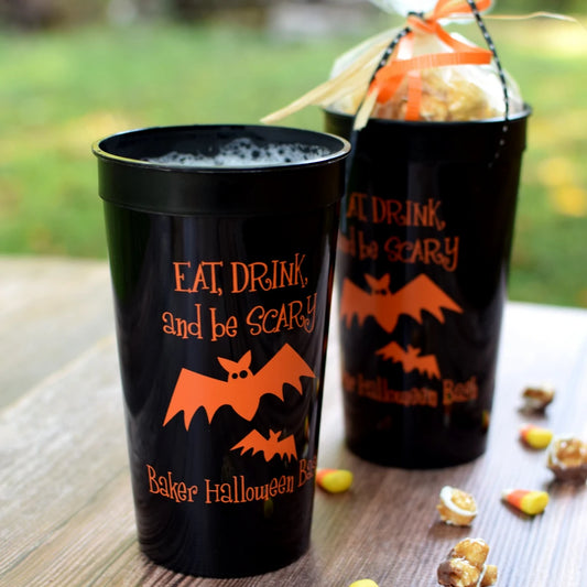Black 32 ounce jumbo halloween party stadium favor cups personalized with Eat Drink and Be Scary design and custom text in orange print