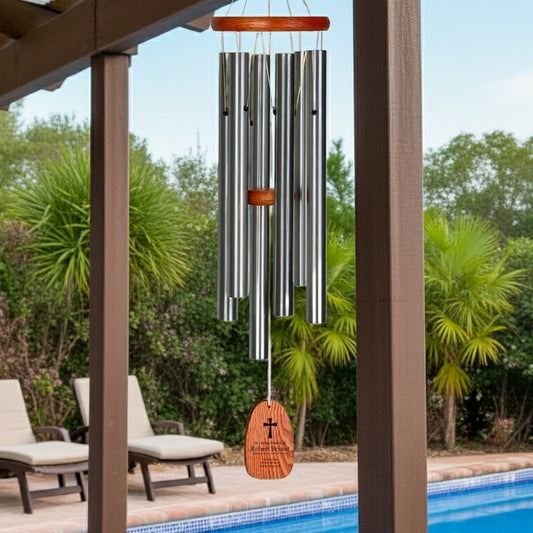 Engraved wind chime memorial gift with metal tubes and wooden top hanging by the pool