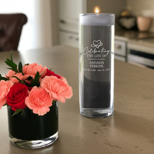Celebration of life memorial candle with personalized engraving and lit wick on table