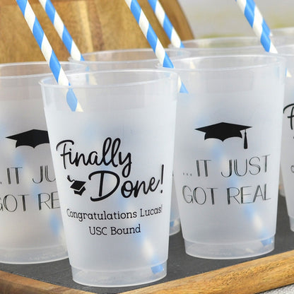 Clear frosted 14 oz. graduation cups personalized with "Finally Done!" design, "Congratulations [Graduate Name]!, USC Bound" and "..IT JUST GOT REAL Grad Cap" design in black print