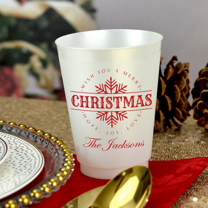 Frosted plastic Christmas party cups with festive red design and personalized text for holiday celebrations