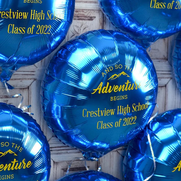 Metallic glue round mylar graduation balloons personalized with adventure begins design and custom text in yellow print