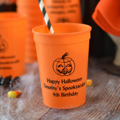 Orange 12 ounce halloween party cups for kids personalized with jack-o-lantern design and custom text in black print