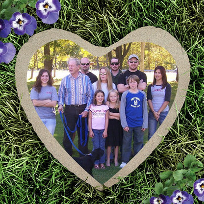 Heart shape custom photo garden stone featuring a family portrait on grass background