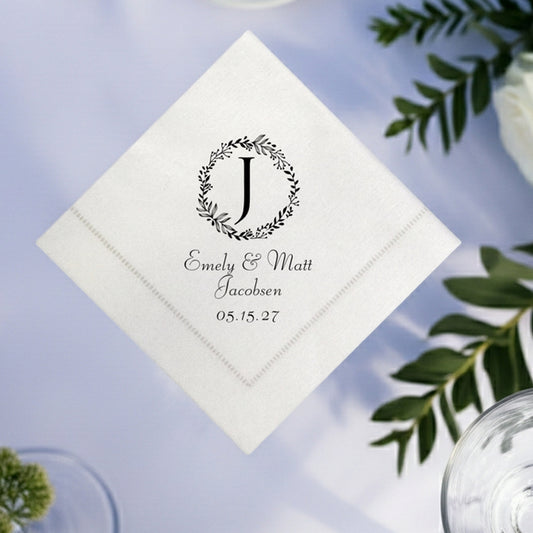 Personalized hemstitch cocktail napkins for weddings featuring a floral wreath and elegant text