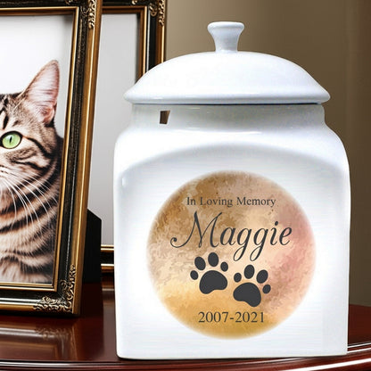 White ceramic in loving memory personalized pet urn with paw prints and name Maggie for 2007 to 2021