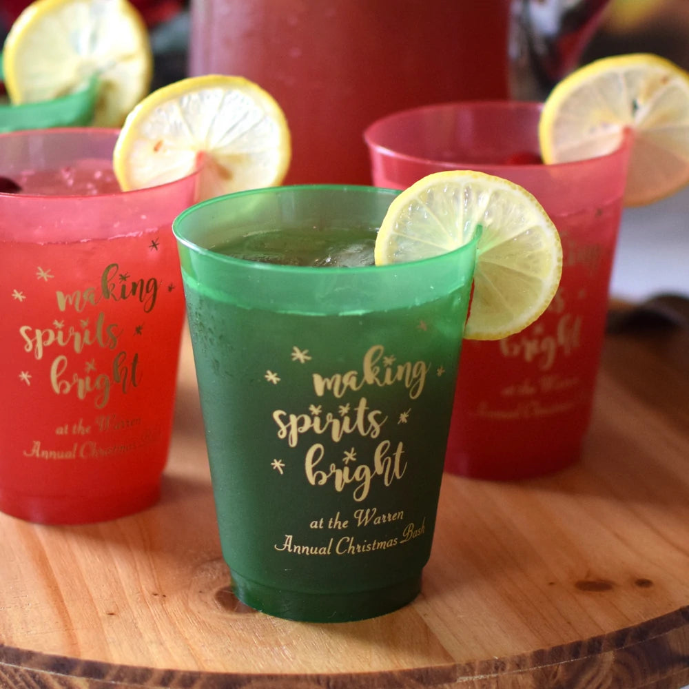 Green and red frosted shatterproof cups personalized for Christmas party with making spirits bright design and custom text in gold print