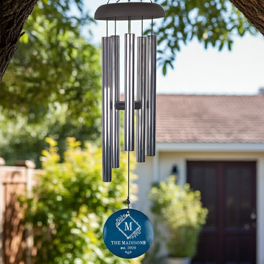 Monogram initial personalized wind chime hanging outdoors with metal tubes and custom family name design