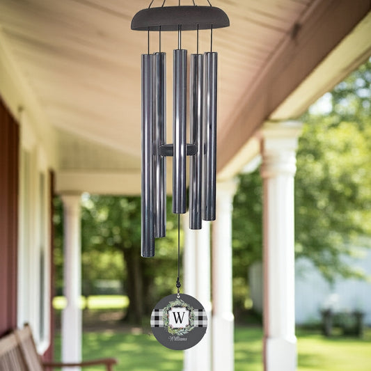 Monogram initial wind chime with metal tubes and custom letter W wind sail hanging on porch