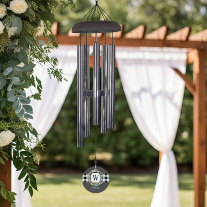 Monogram initial wind chime with metal tubes and personalized round wind sail hanging outdoors