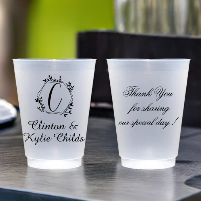 Clear frosted wedding cocktail cups personalized with geometric wreath monogram C and custom text on front side and 3 lines of text on back side in black print