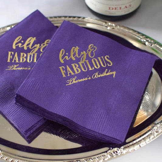 purple 3-ply paper adult birthday party cocktail napkins personalized with fifty & fabulous design and custom text in gold print