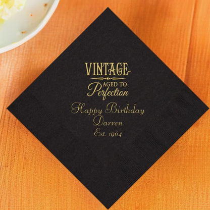 Black color adult birthday dinner napkin personalized with aged to perfection design and custom text in gold print