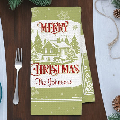 Personalized Christmas kitchen hand towel featuring a festive design with a house and trees with custom family name