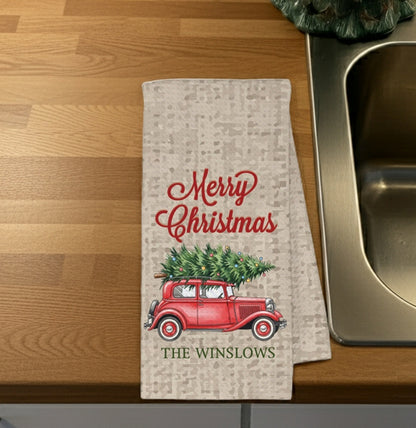 Christmas kitchen towel featuring a red car with a Christmas tree and Merry Christmas design personalized with family name