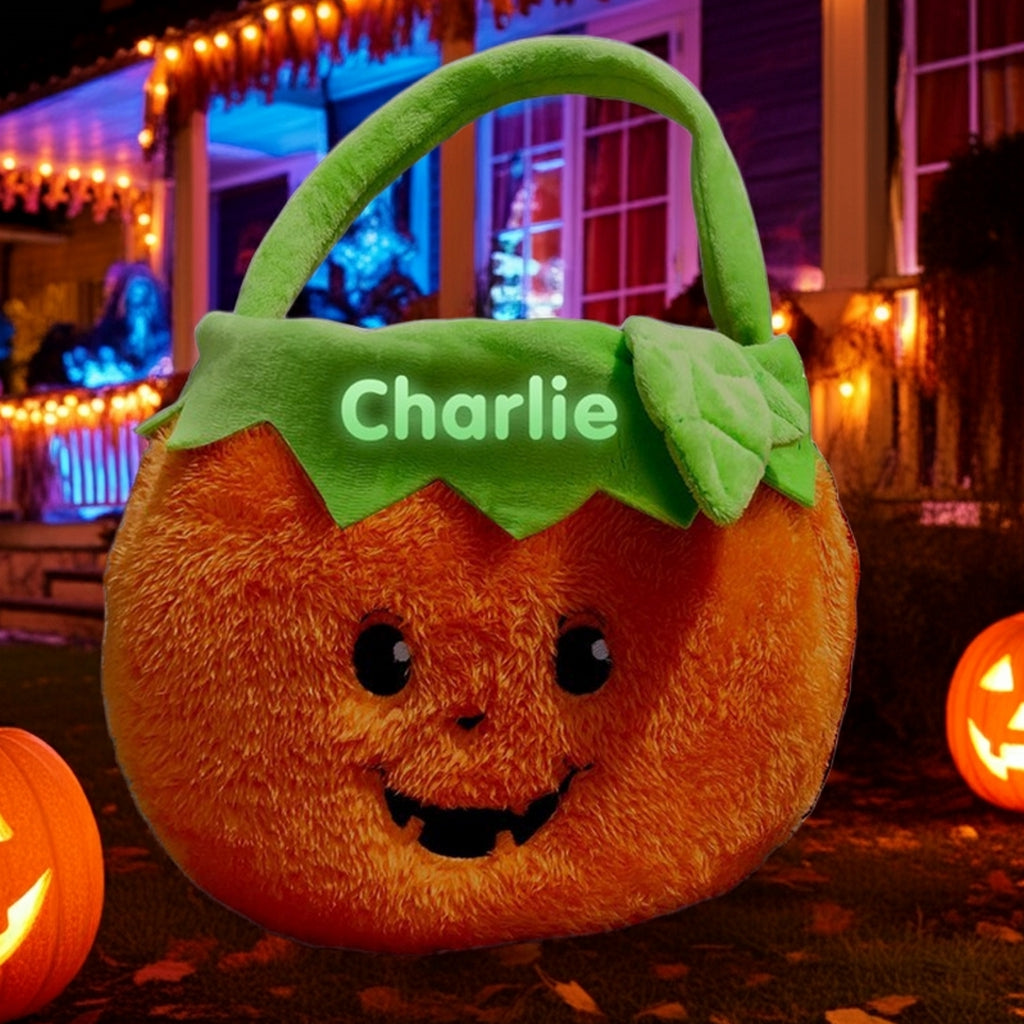 Personalized glow in the dark trick or treat basket shaped like a smiling pumpkin with green handle and leaf