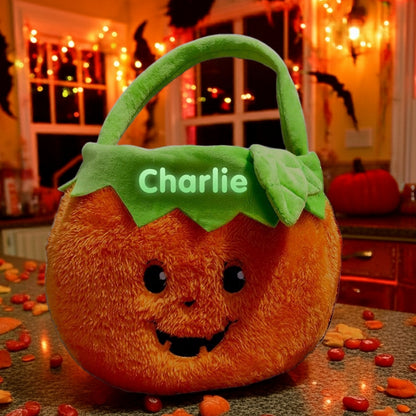 Personalized glow in the dark trick or treat basket shaped like a plush pumpkin with green handle and custom name Charlie
