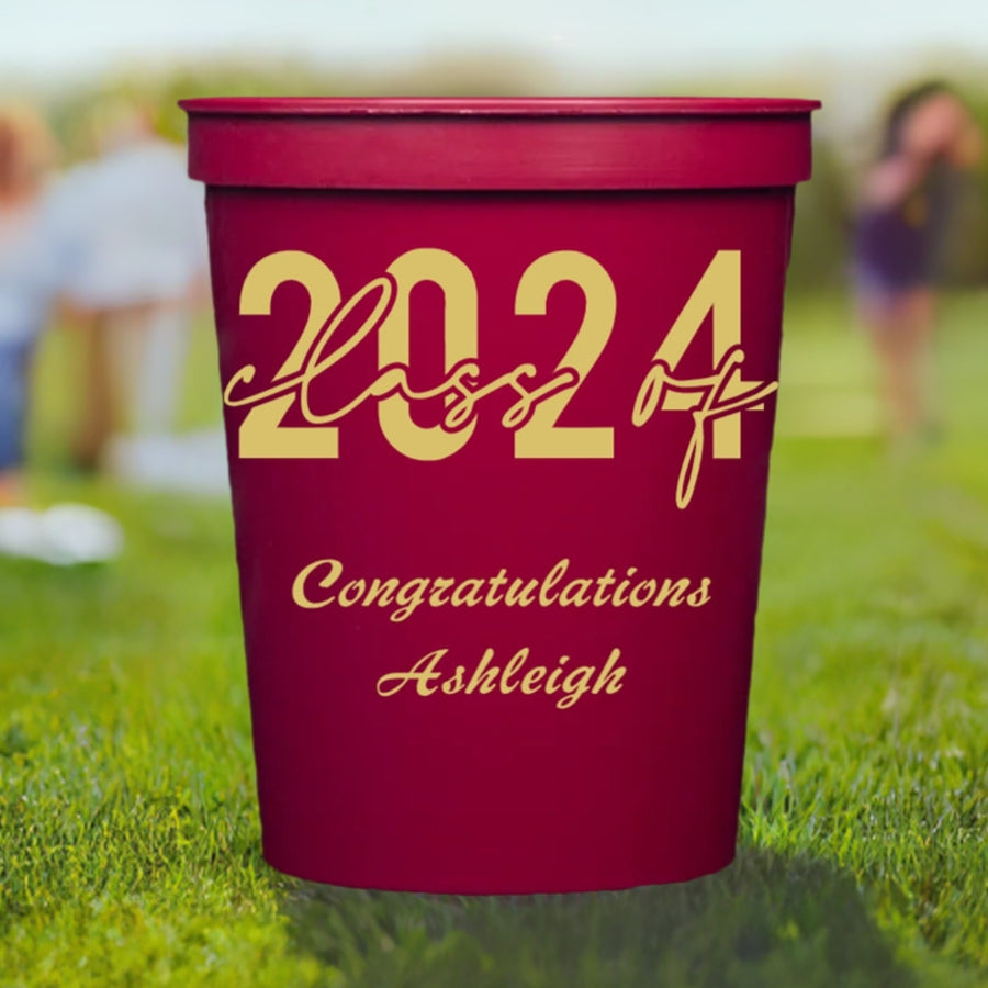 a maroon color graduation cup personalized with class of 2024 design and 2 lines of text in gold print