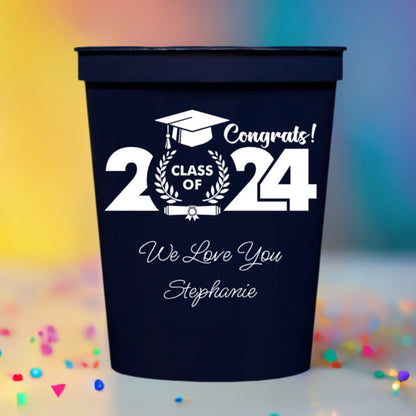 a navy color graduation party cup personalized with class of 2024 cap and diploma design and 2 lines of text in white print