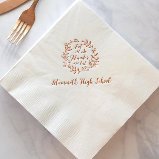 White paper graduation dinner napkns personalized with all who wander design and custom text in copper print