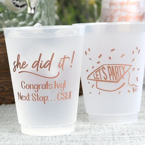 16 oz size shatterproof frosted cups personalized for graduation party with she did it! design and 2 lines of text on the front, lets party graduation cap design on back in copper print
