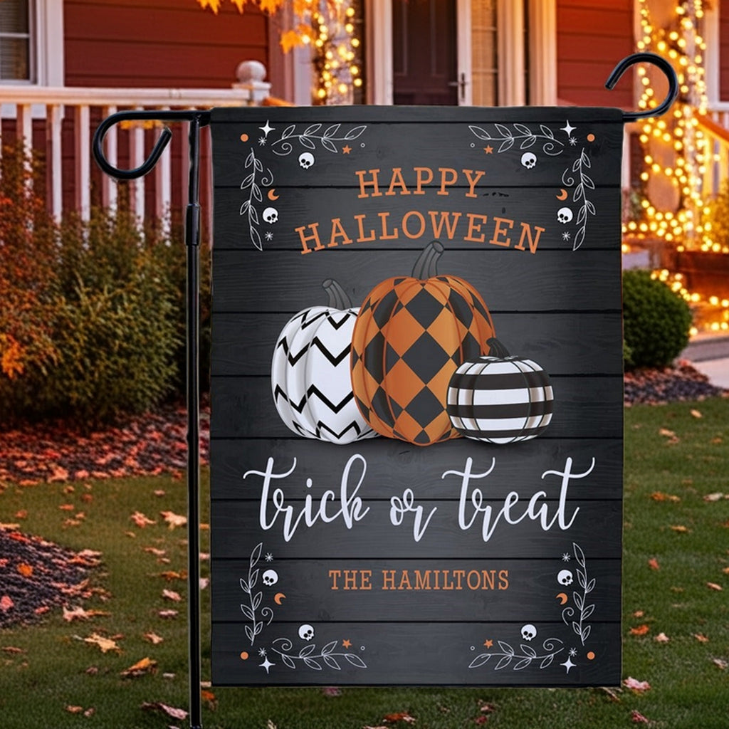 Personalized Halloween garden flag showing three patterned pumpkins and Happy Halloween trick or treat The Hamiltons