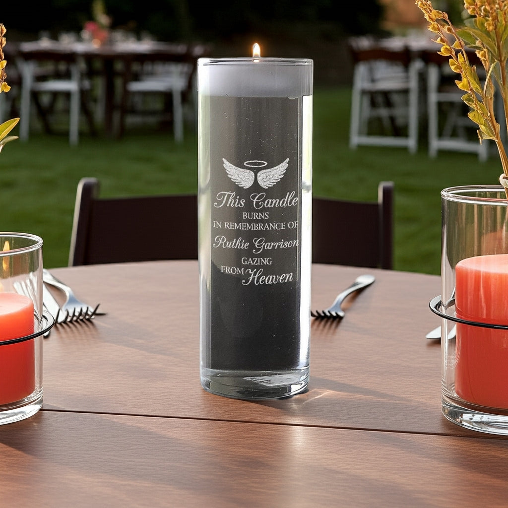 Personalized memorial candle with angel wings and remembrance text on wooden table outdoors