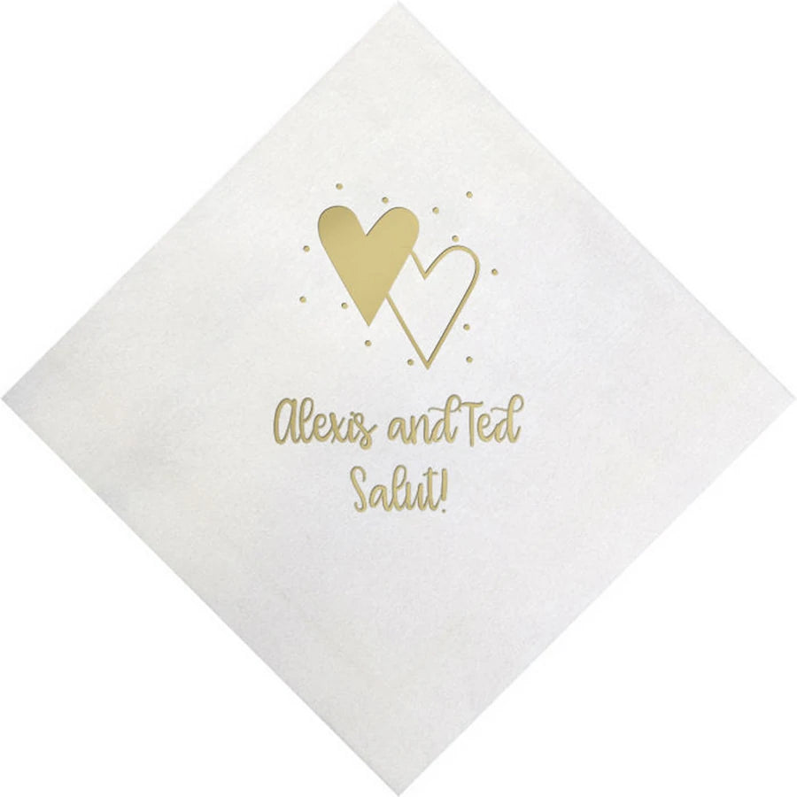 White color bella wedding beverage napkin personalized with heart confetti design and two lines of text in gold print