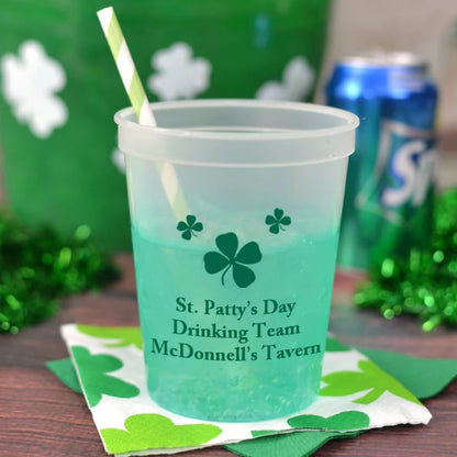 Transparent color 16 oz. saint patricks day party cup personalized with shamrocks design and 3 lines of text in green print sitting on party table