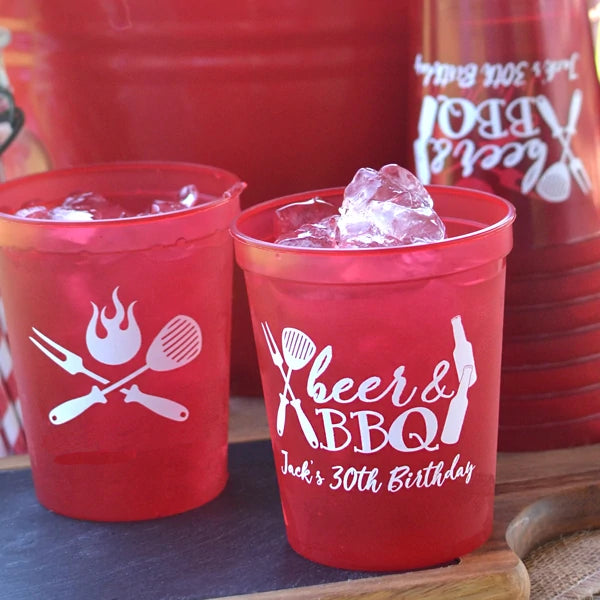 Translucent red color summer party cups personalized with beer and bbq design and custom text on front side and grilling utensils design on back side in white print