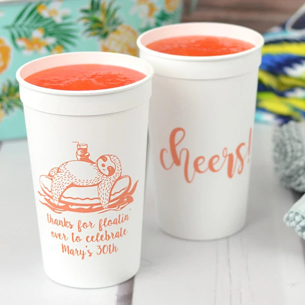White 22 oz stadium cups personalized for summer birthday with floating sloth design and custom text on front side and cheers design on back side in light coral print