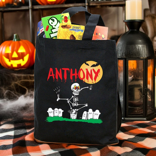 Black Halloween tote with skeleton and tombstones named Anthony full of candy personalized trick or treat bag