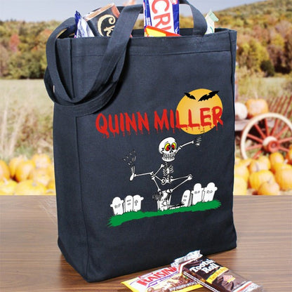Black personalized trick or treat bag with skeleton graveyard design and red name Quinn Miller filled with candy