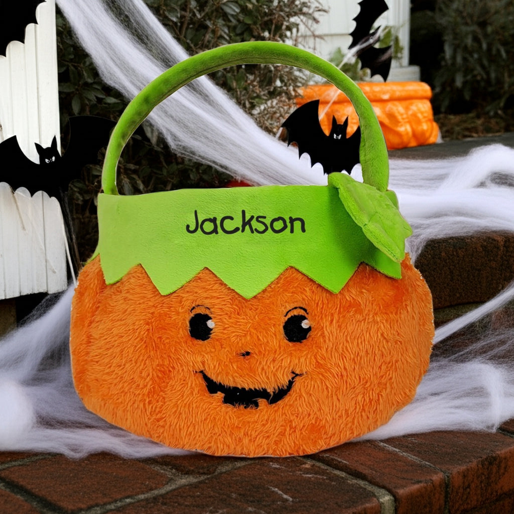 Personalized trick or treat candy basket shaped like a smiling pumpkin with a green handle and name Jackson