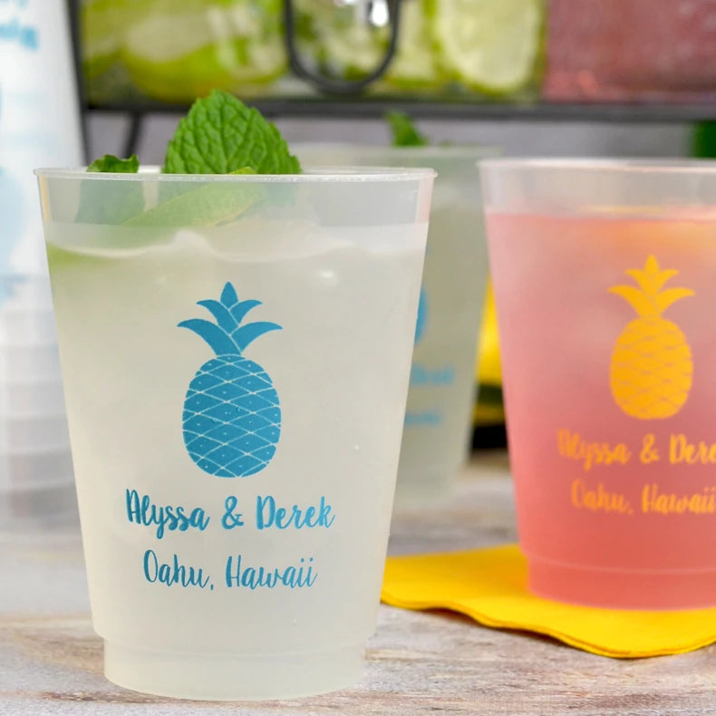 Clear frosted 16 oz. cups personalized with 'Pineapple' design and two lines of custom text in neon blue imprint color