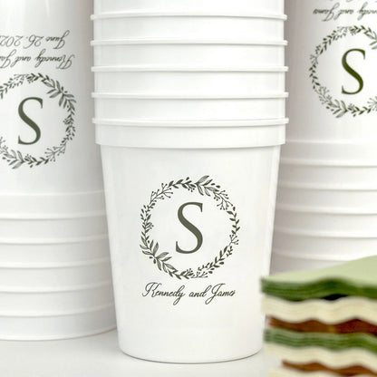 Set of personalized wedding cups featuring a floral monogram and custom names for celebrations