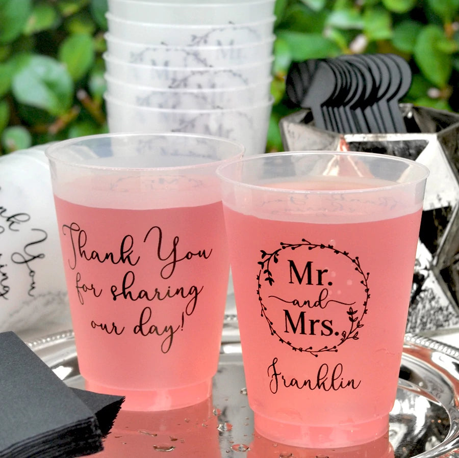Clear frosted 16 ounce shatterproof wedding cocktail cups personalized with Mr and Mrs Wreath wedding design and 1 line of text on the front and 3 lines of custom text on the back in black print