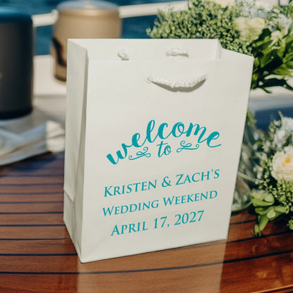 White Tippytoad wedding welcome bags custom printed with teal welcome text for Kristen and Zachs wedding weekend