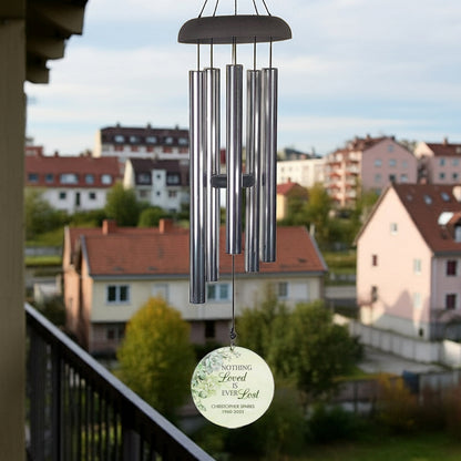 Personalized wind chime memorial with metal tubes and engraved round pendant hanging outdoors