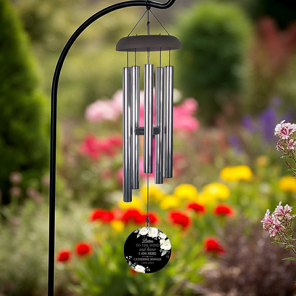 Personalized wind chime memorial with silver tubes and floral engraved pendant in garden