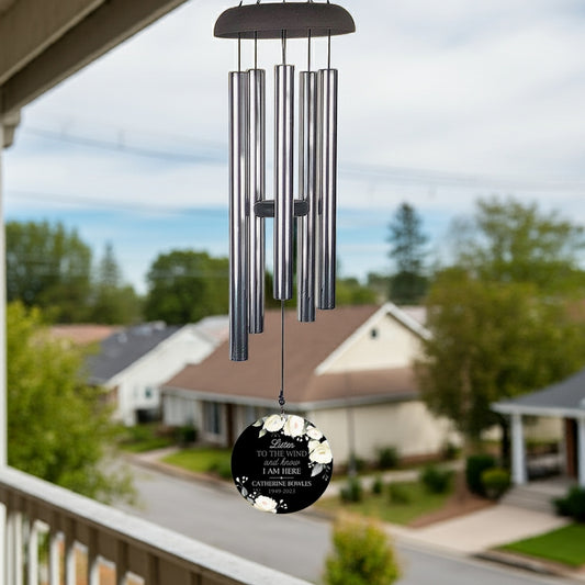 Personalized wind chime memorial with a black round pendant and floral design hanging outdoors