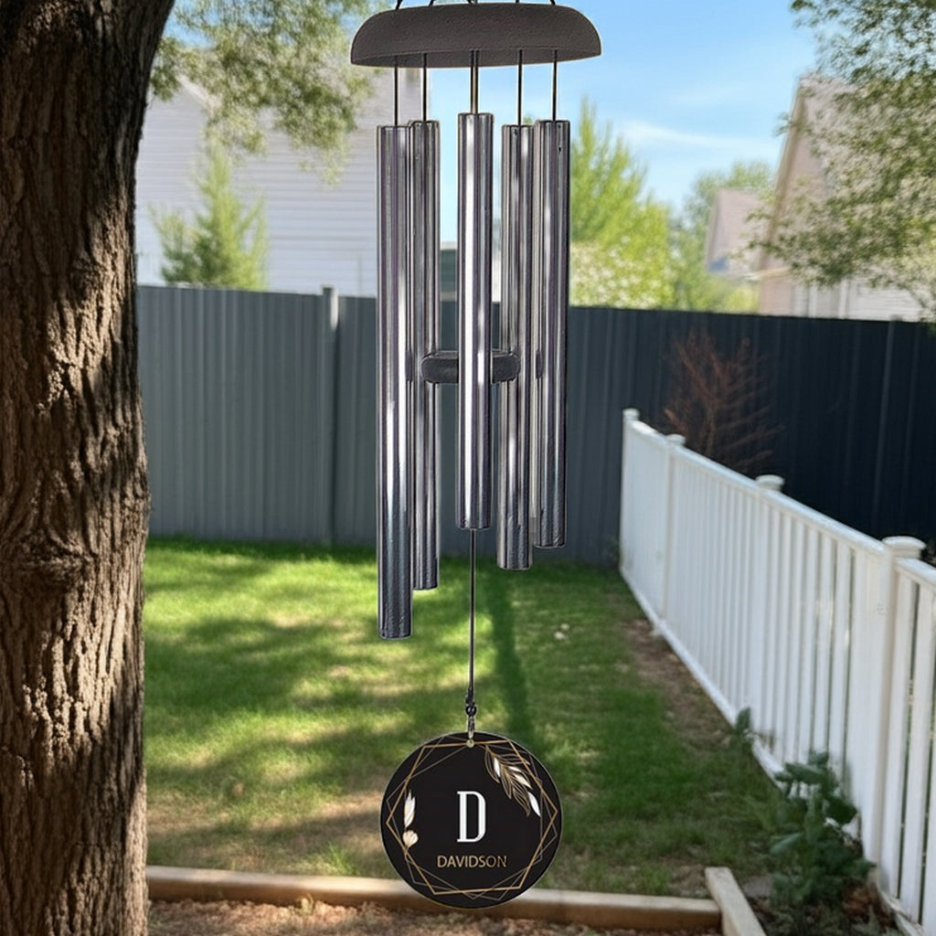 Personalized wind chime hanging outdoors with metal tubes and custom initial design